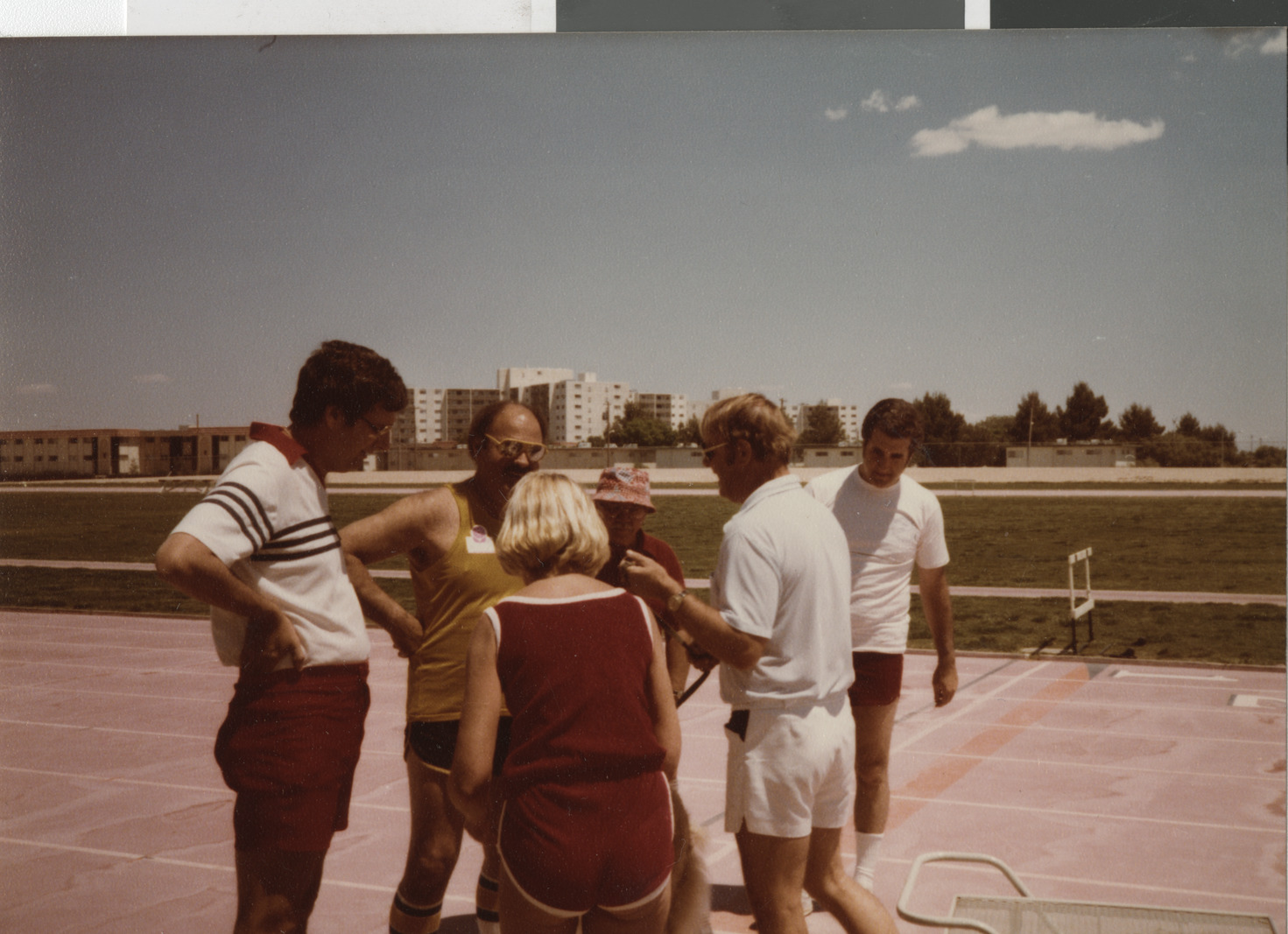 Photograph of Ron Lurie and others on a track