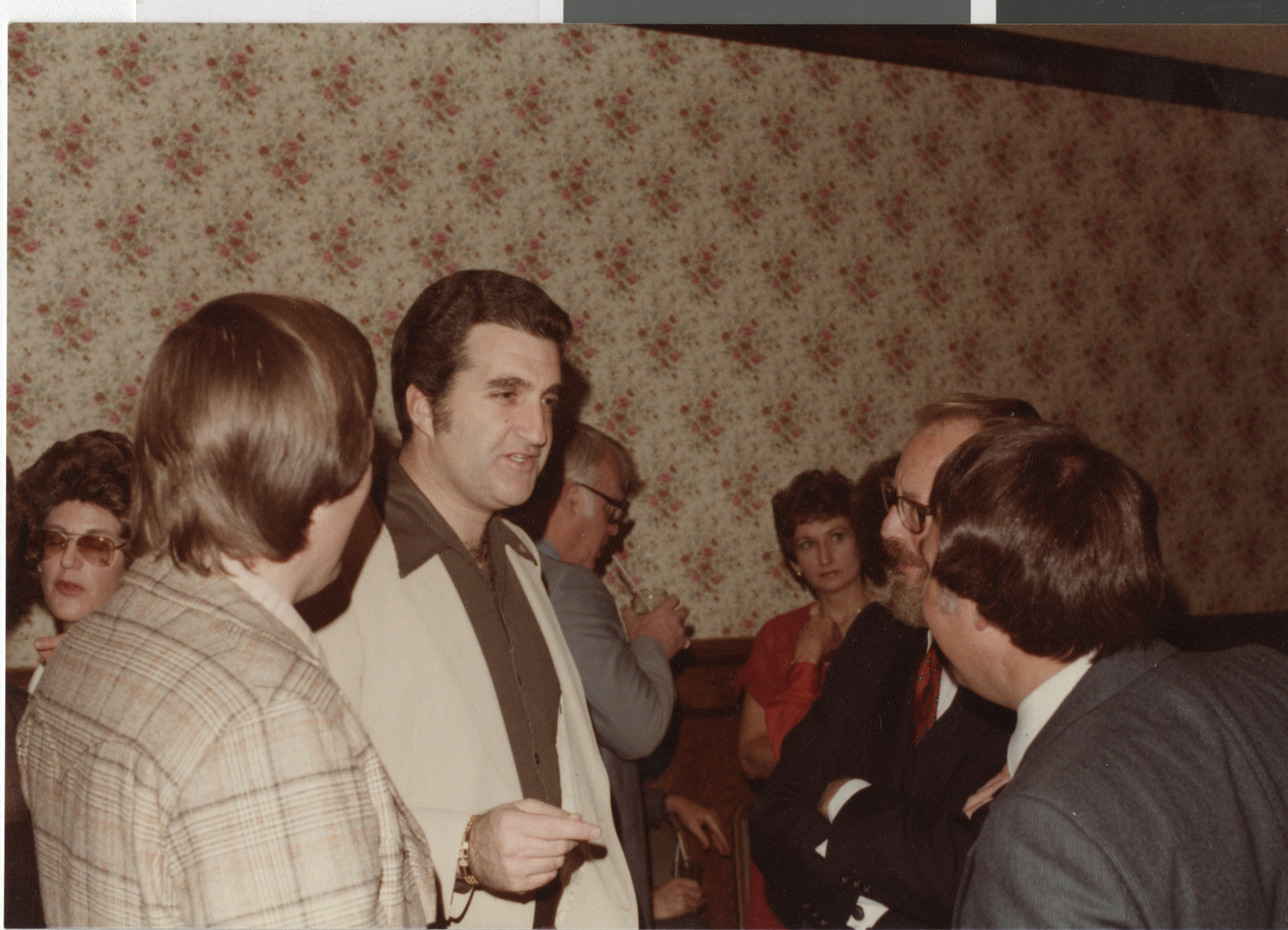 Photograph of Ron Lurie speaking with a group of men