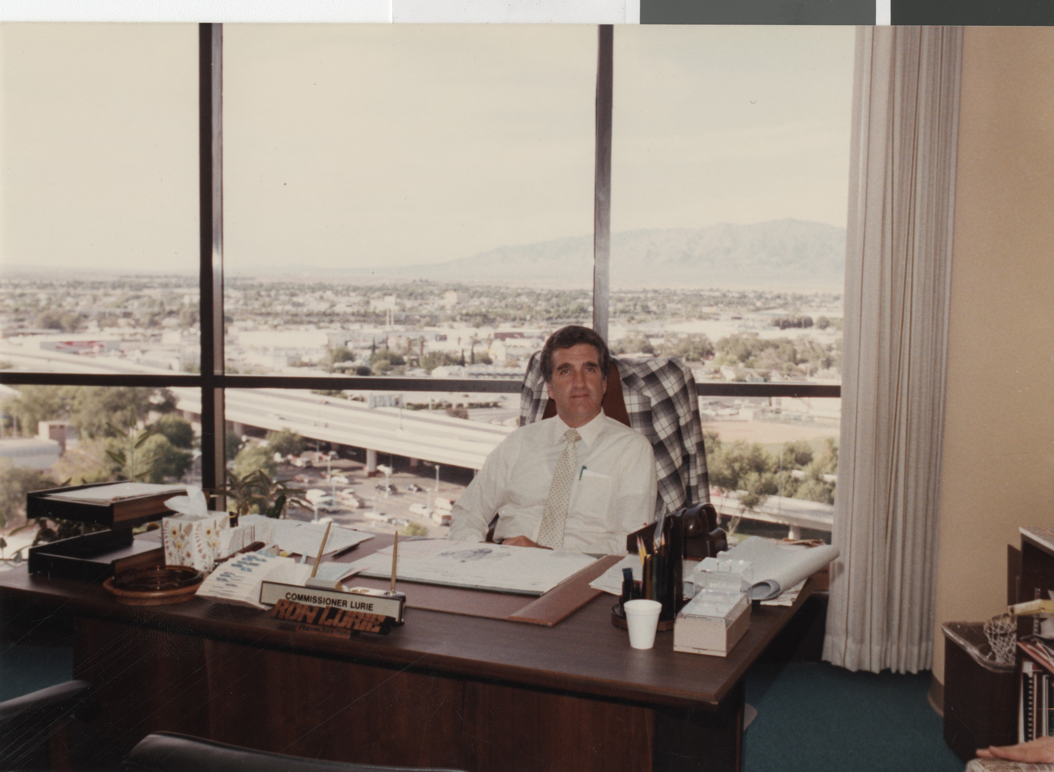 Photograph of Ron Lurie seated at his desk