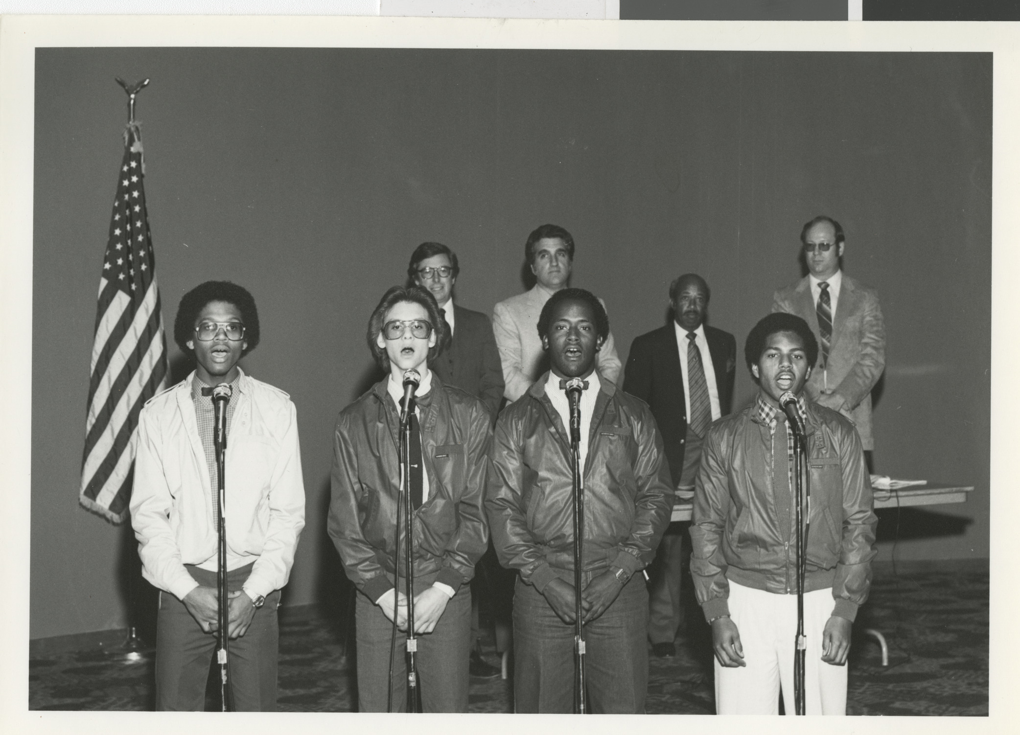Photograph of Exdex Singing Group performing (Governor List and Ron Lurie in the background)