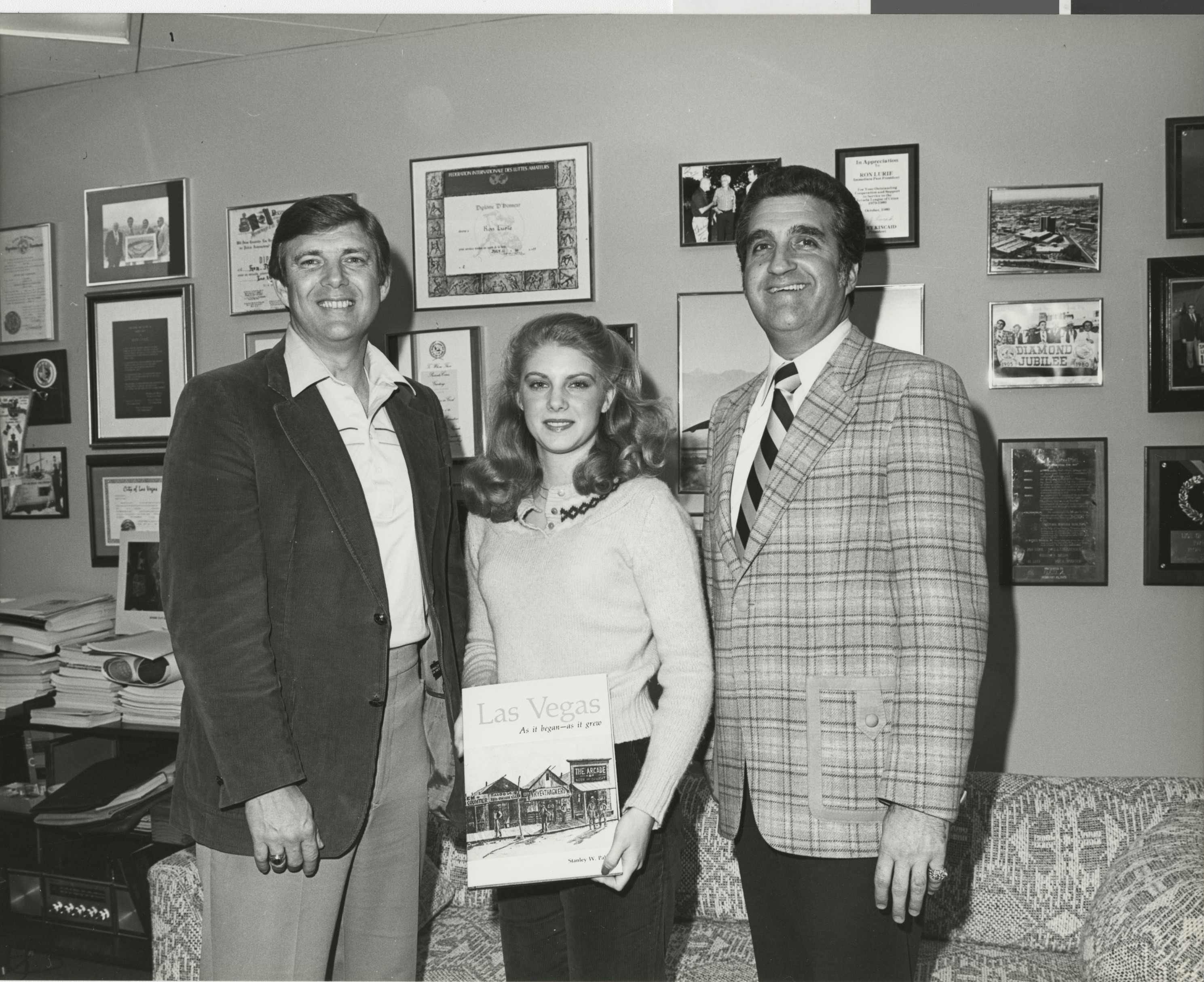 Photograph of Ron Lurie (right) with two others (one holds the book "Las Vegas As it began - As it grew")