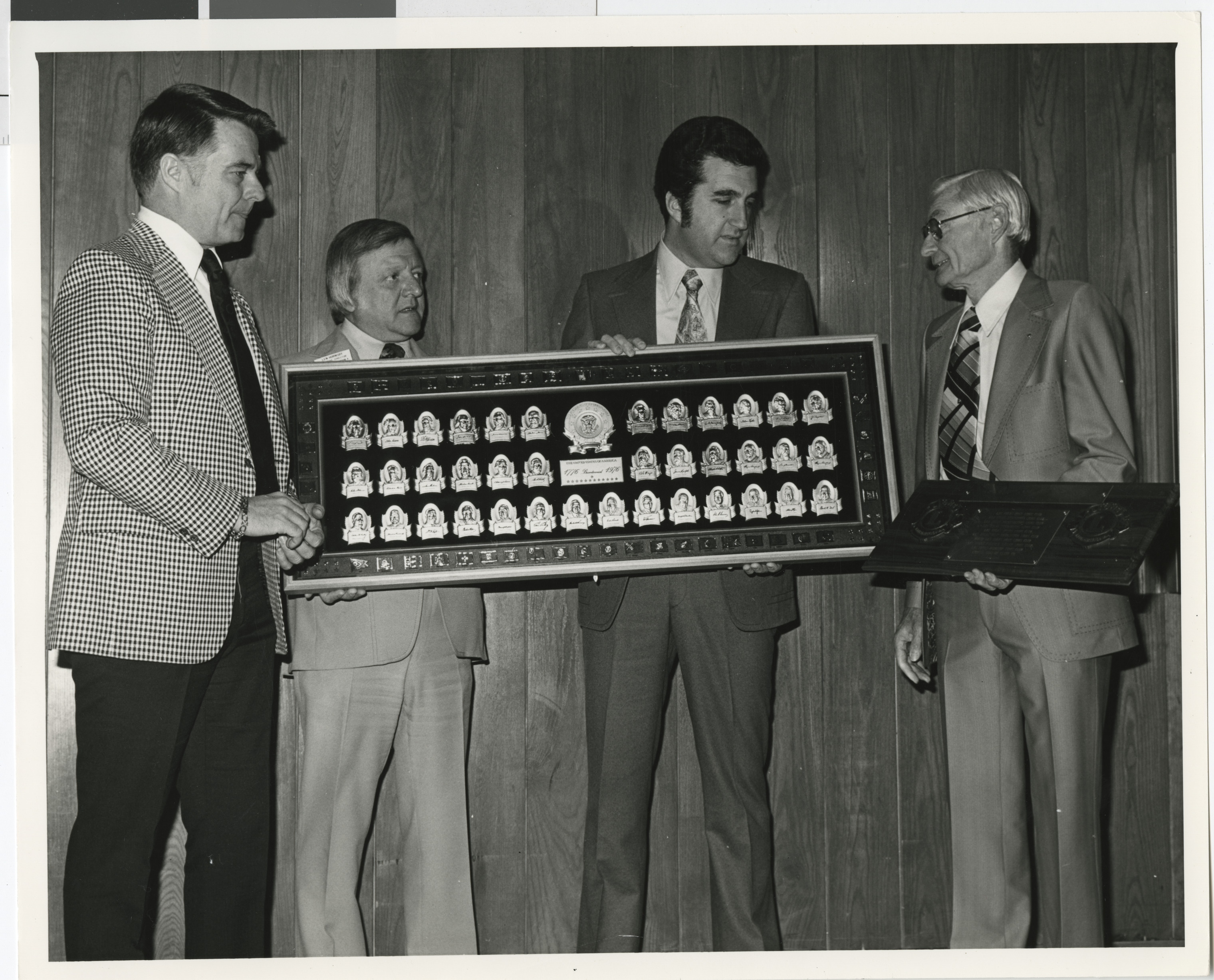 Photograph of Ron Lurie presenting a framed plaque to a group