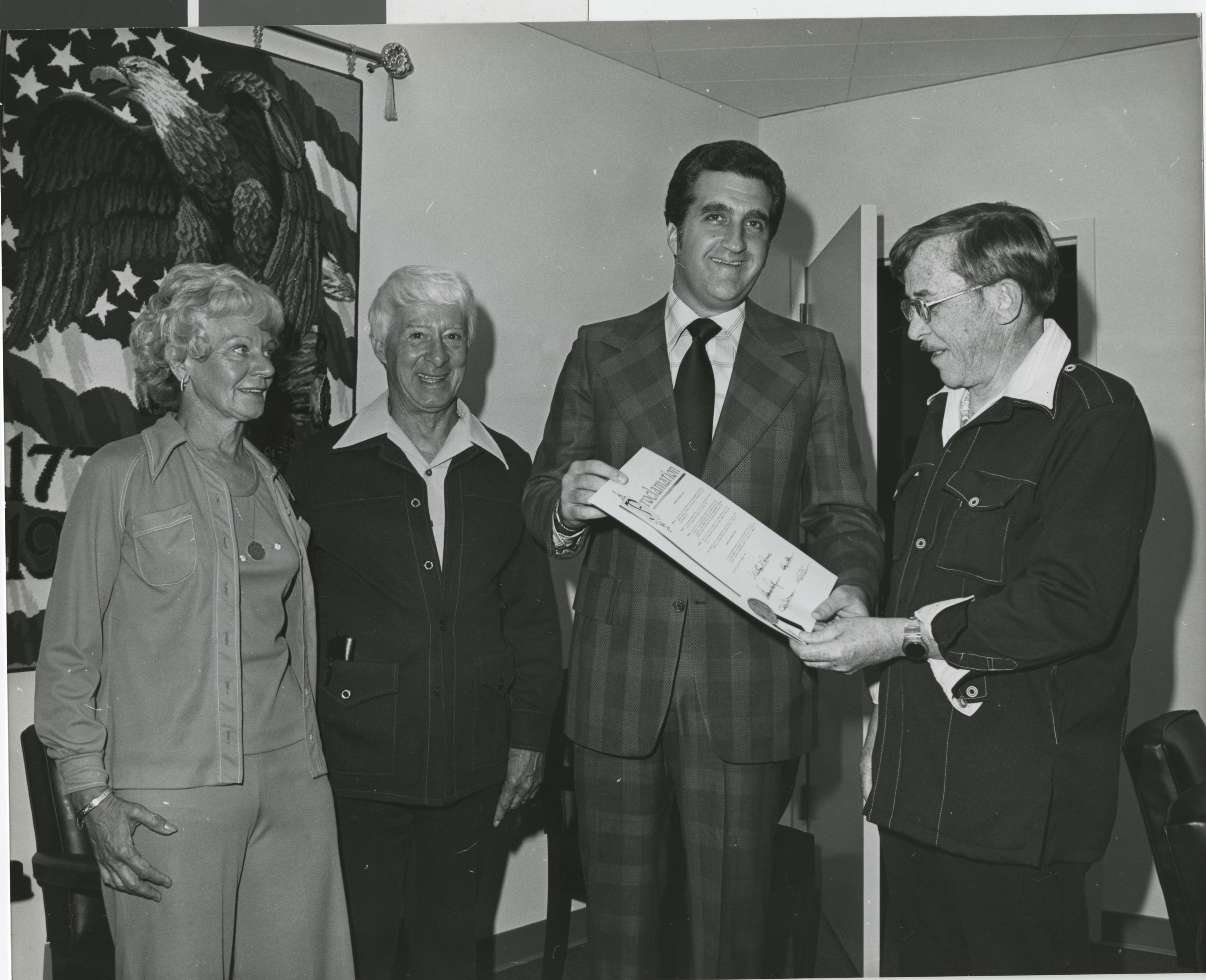 Photograph of Ron Lurie presenting a proclamation to a group