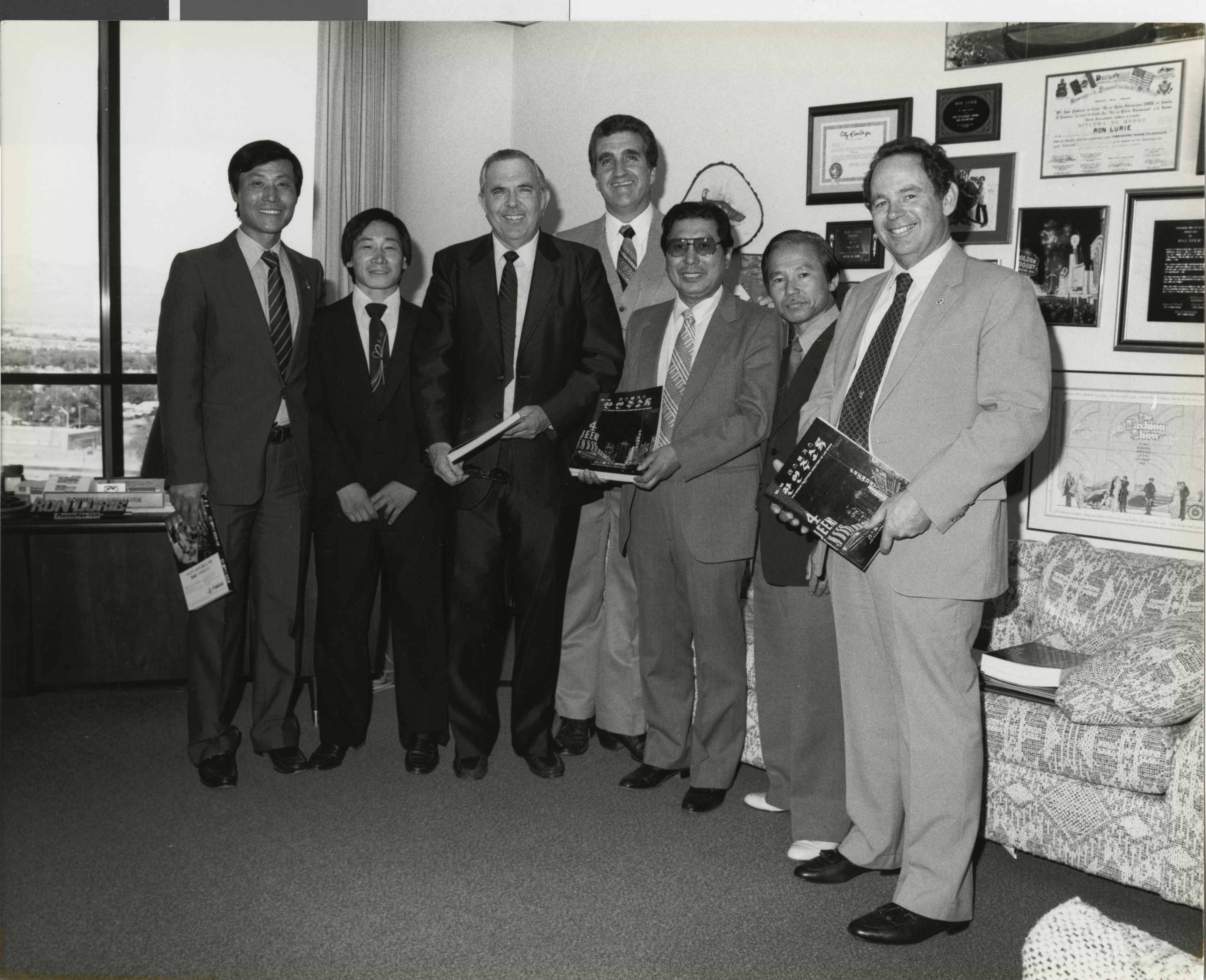 Photograph of presentation by Steven Kwon & members of the Korean association of Las Vegas of their directory to councilmen. Left to right: Paul Christensen, Ron Lurie & Al Levy, October 19, 1983