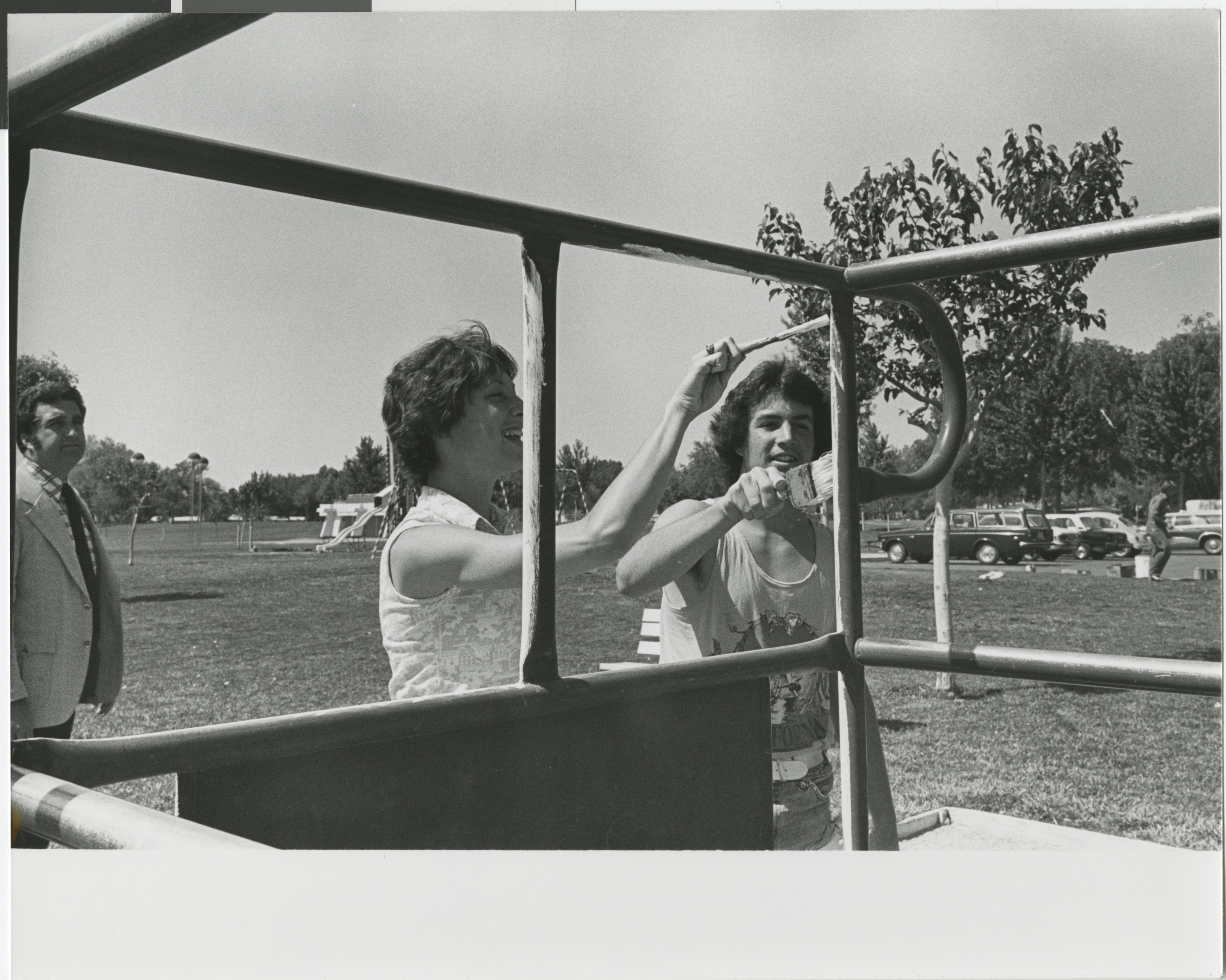 Photograph of Ron Lurie with community members painting playground equipment