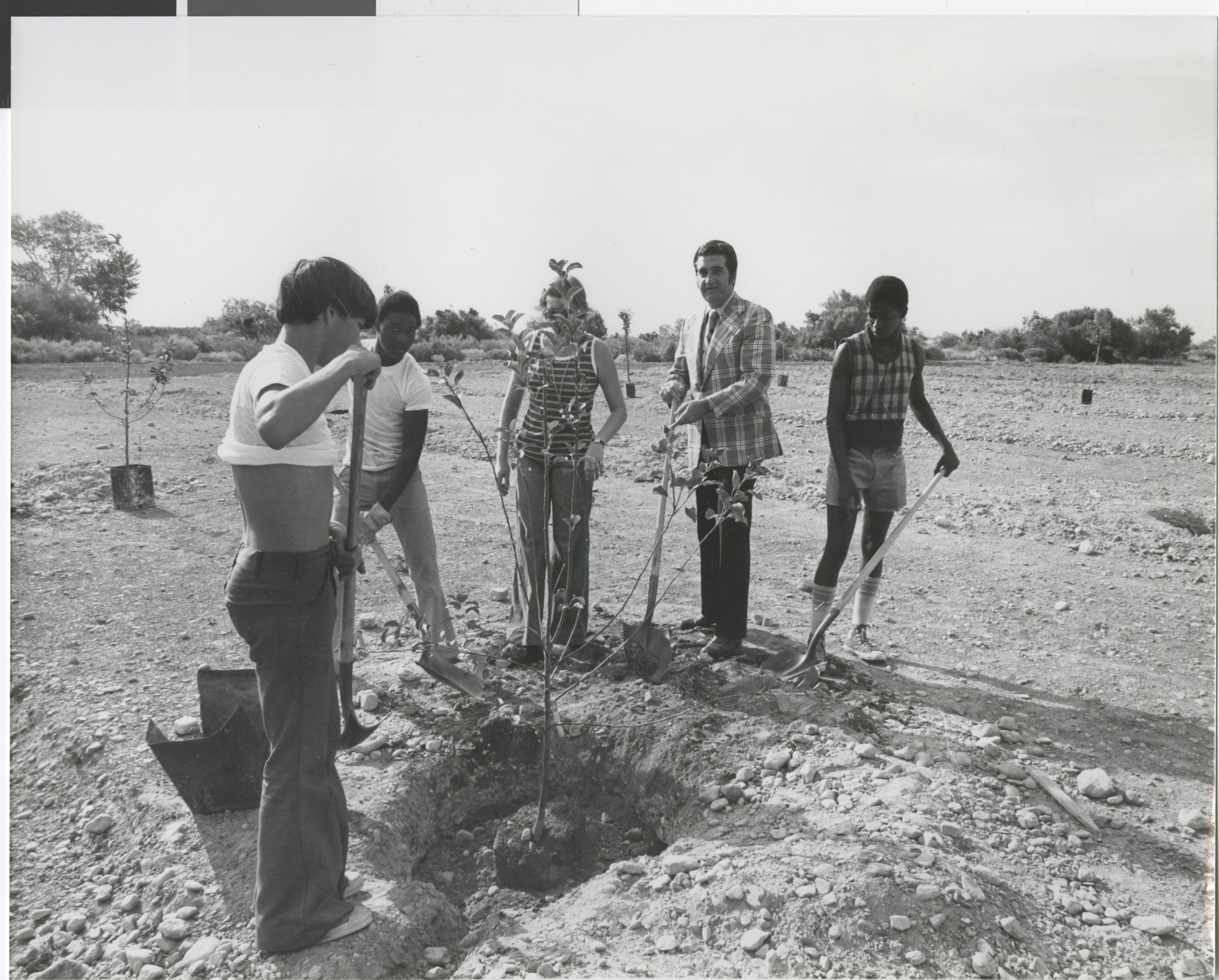 Photograph of Ron Lurie with community members planting trees