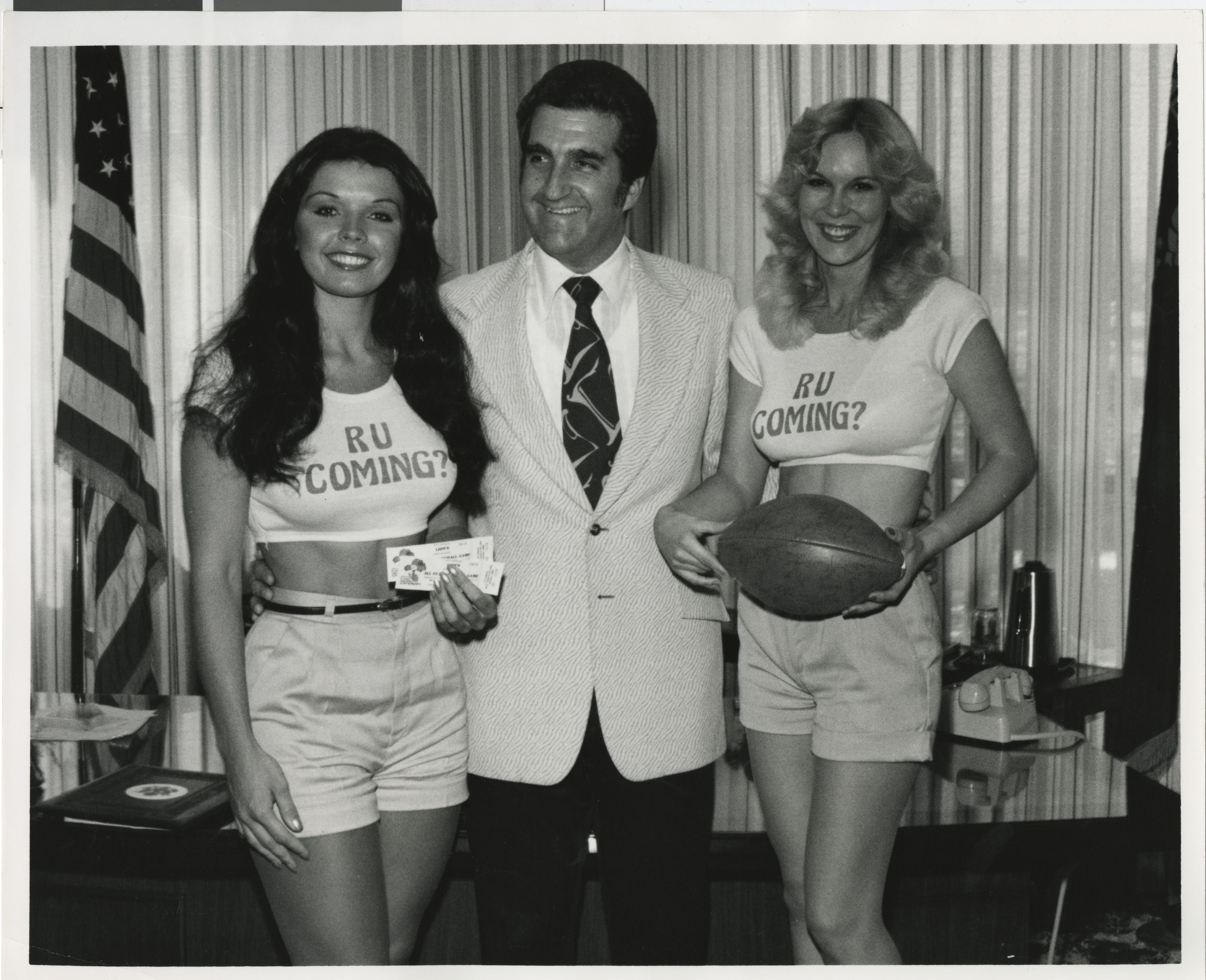 Photograph of Ron Lurie with two women in crop-tops