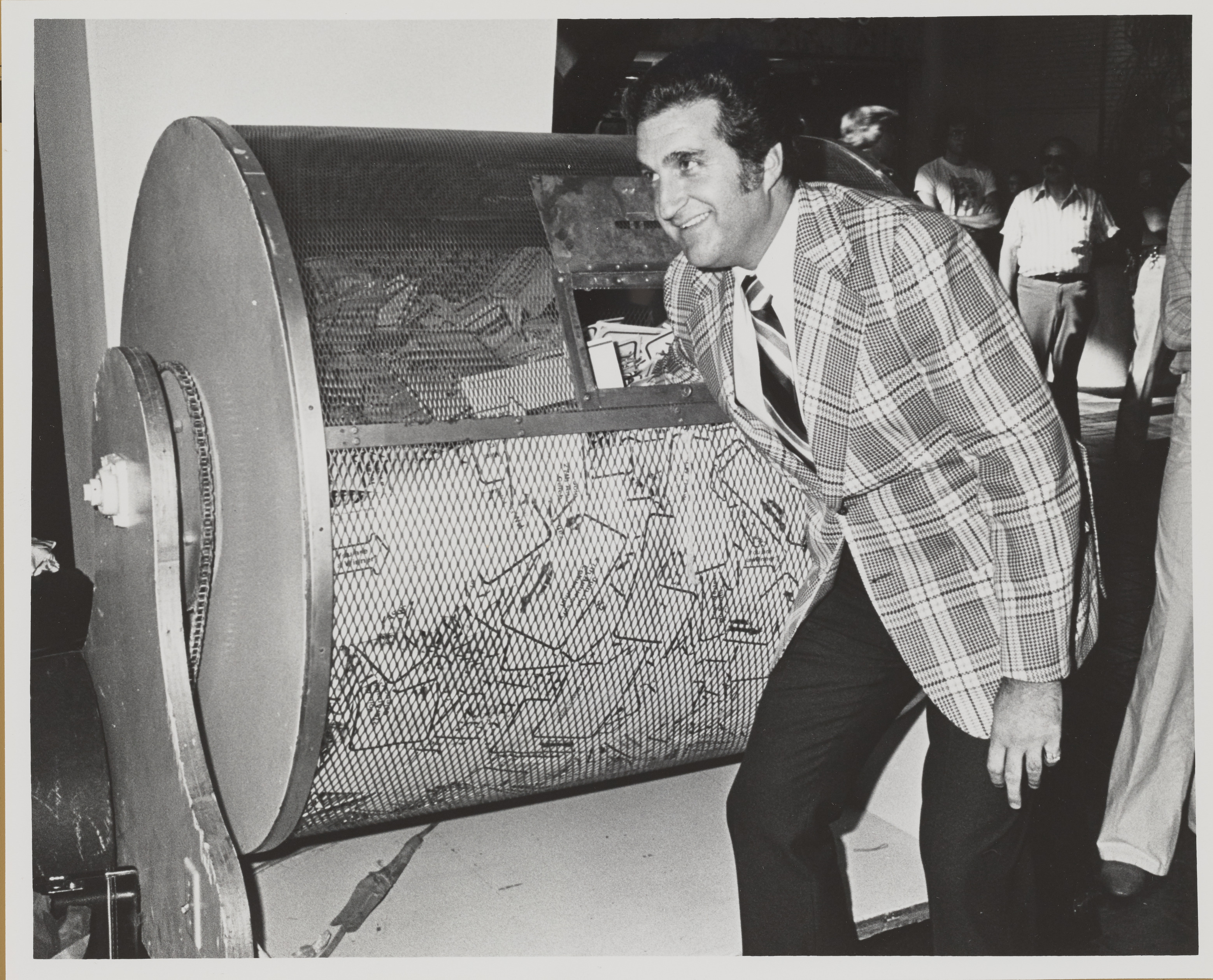 Photograph of Ron Lurie picking a winning ticket from barrel, 1979