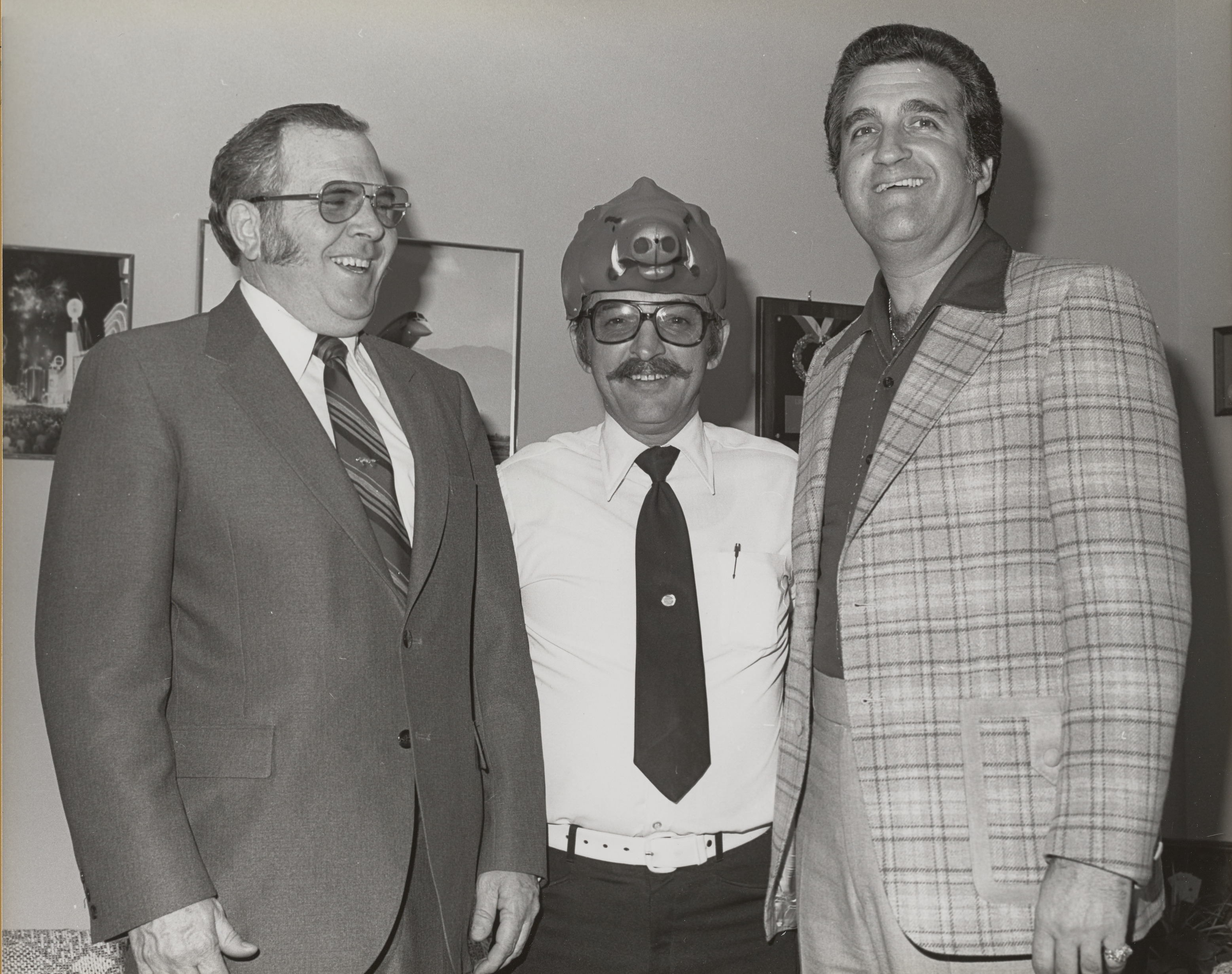 Photograph of Ron Lurie with a man wearing a pig hat and another unidentified man
