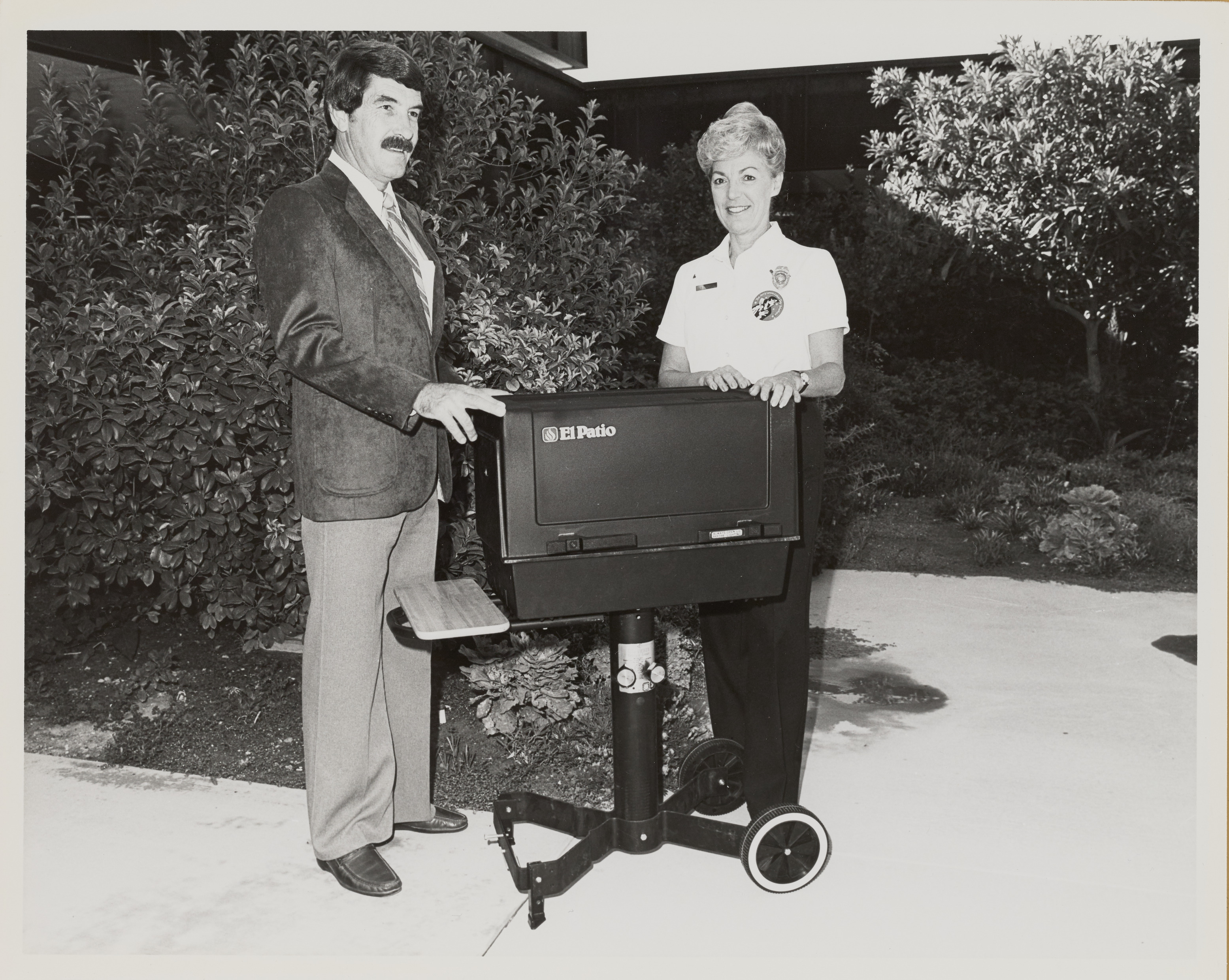 Photograph of two people with an El Patio grill