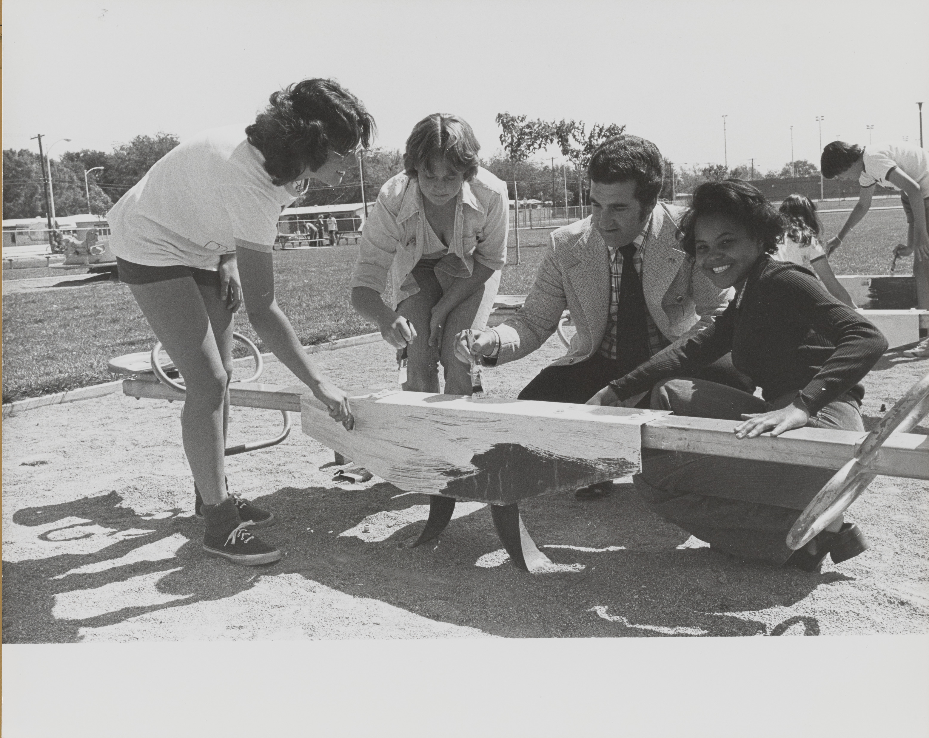 Photograph of  Ron Lurie helping with painting a see-saw