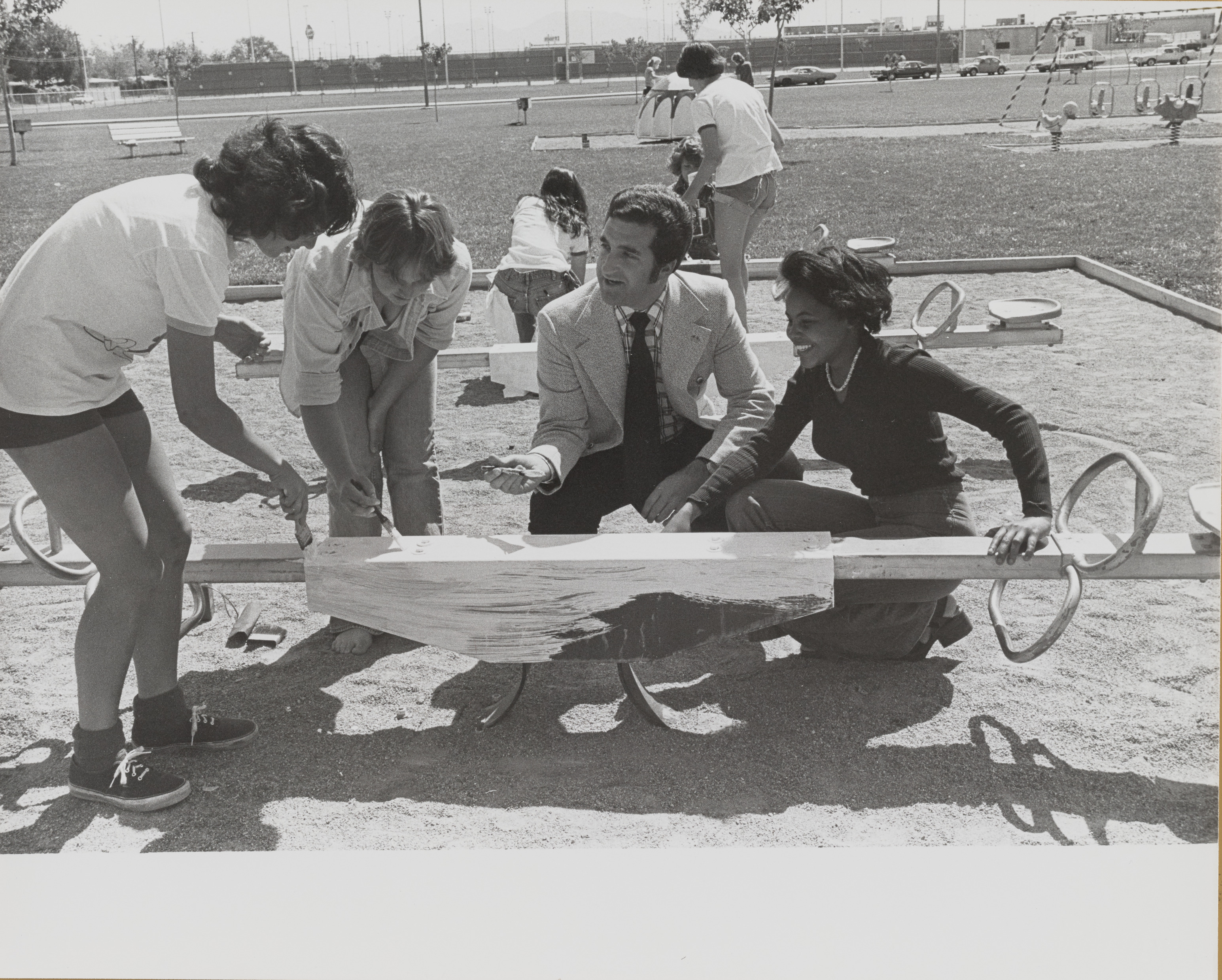 Photograph of  Ron Lurie helping with painting a see-saw