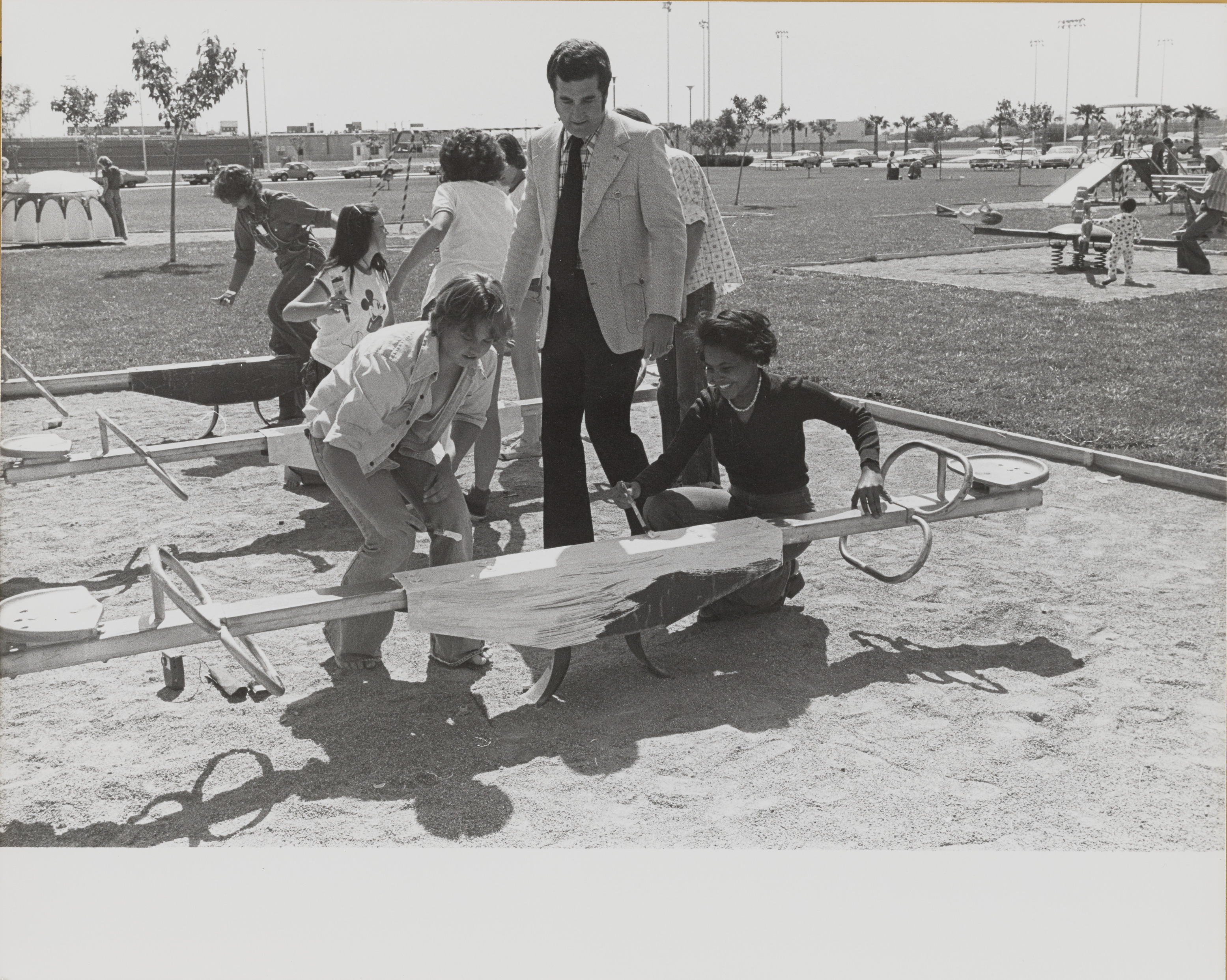 Photograph of  Ron Lurie helping with painting a see-saw