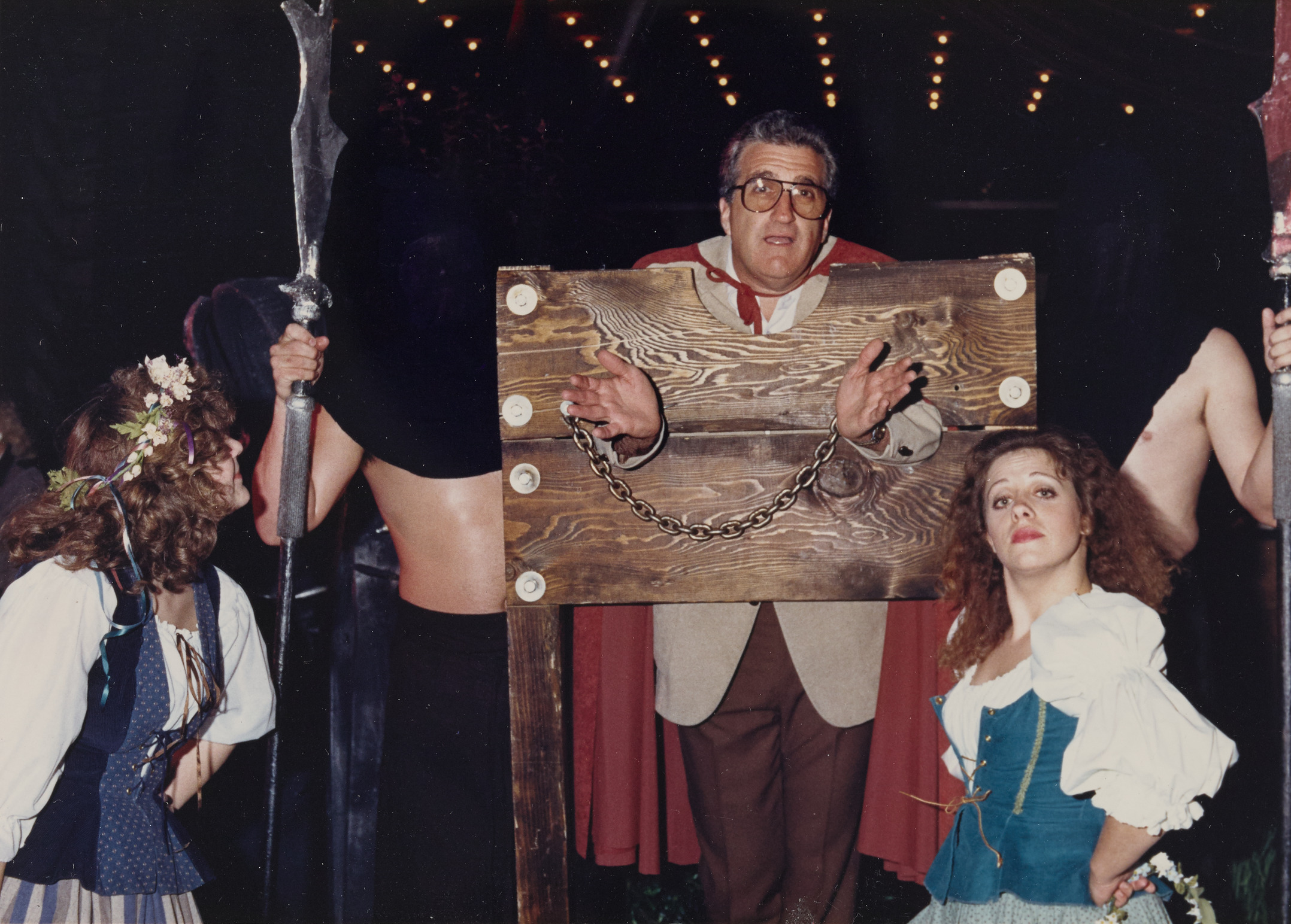 Photograph of Ron Lurie in a guillotine, 1988