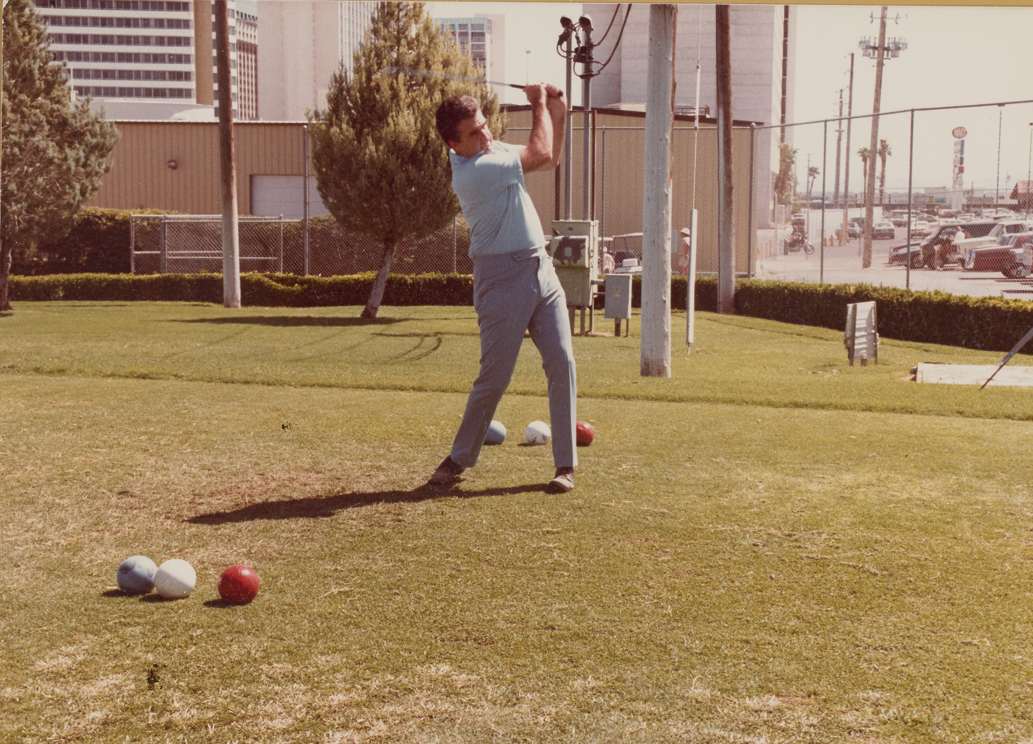 Photograph of Mayor Ron Lurie swinging a golf club