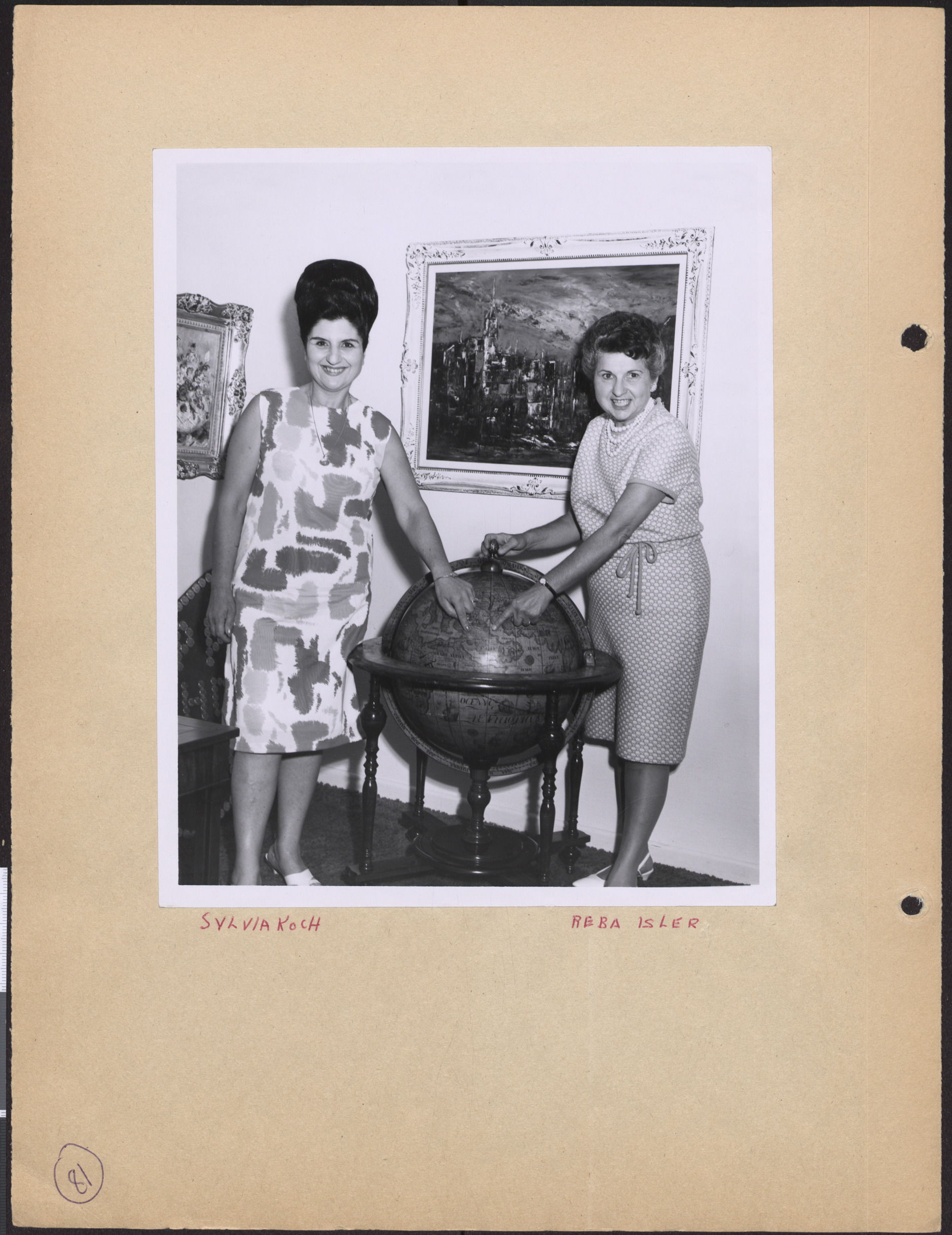 Photograph of Sylvia Koch and Reba Isler pointing at a globe