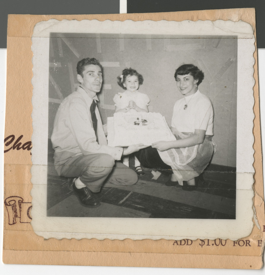 Photograph of Shelley (Levine) Berkley with her parents holding a cake, 1950s