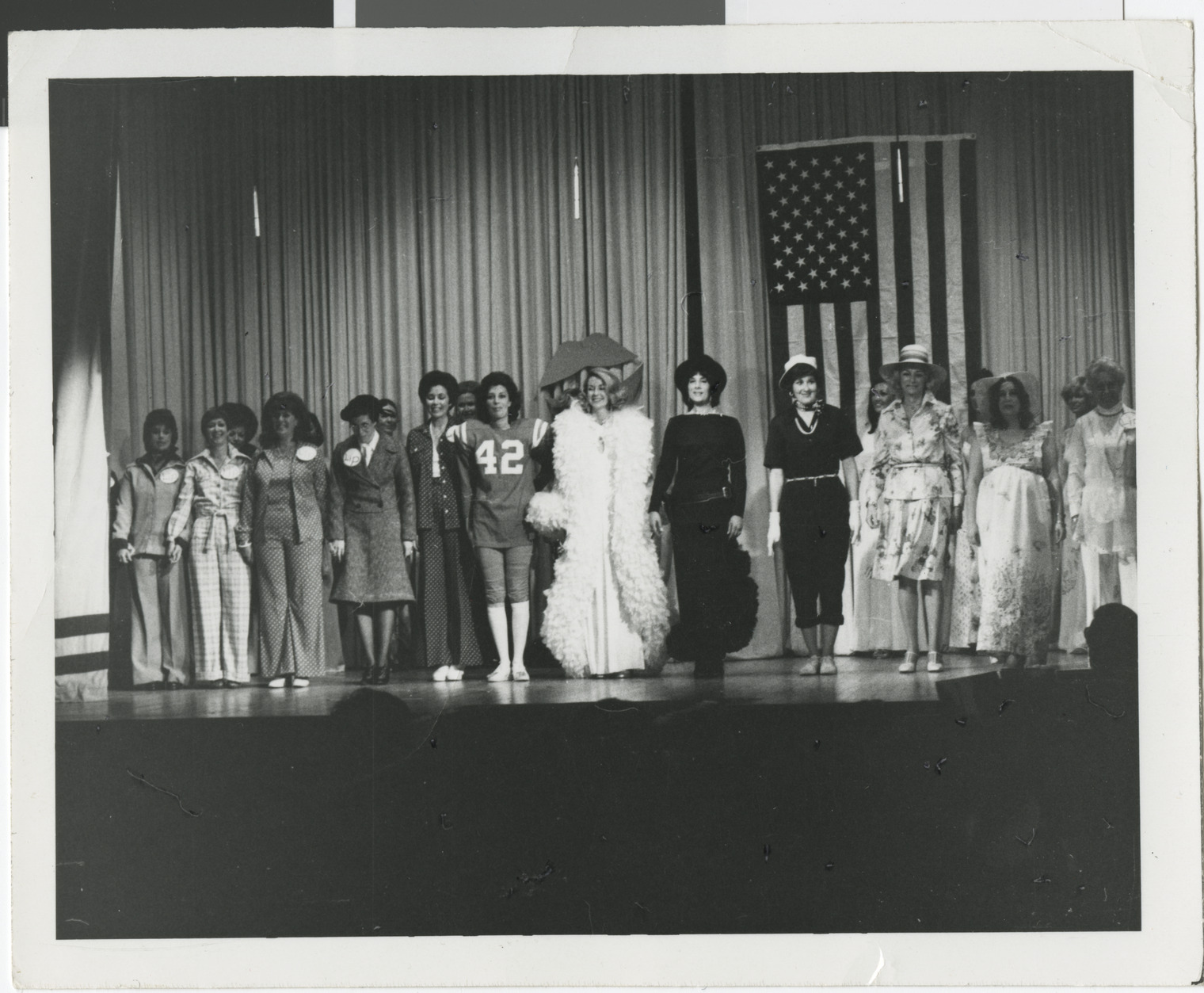 Photograph of actors on stage with Wilma Bass in jersey